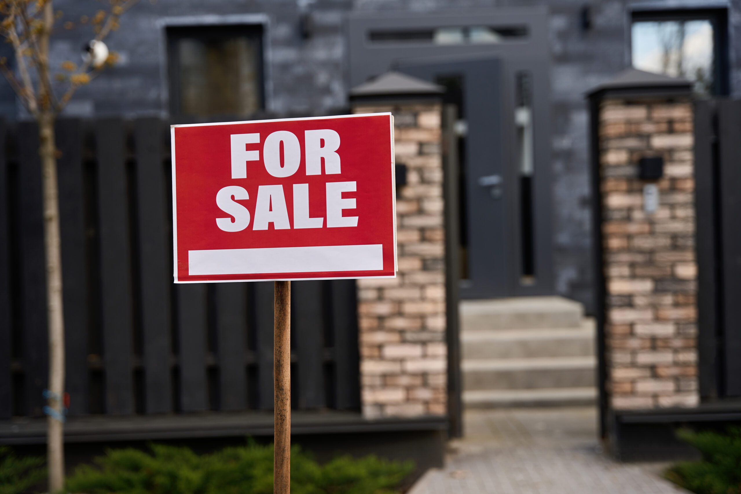 Sale notice installed on the lawn near the entrance to the house